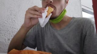 Cara comendo enroladinho