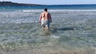 Je baigne mon énorme ventre de chubby dans la mer