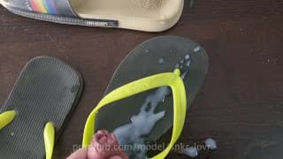 穿着白色肮脏的阿迪达斯袜子的人字拖 havaianas 和幻灯片上的巨大射精