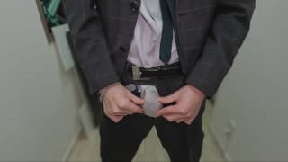 一个穿着西装的男孩用手自慰，裤子里浸满了精液